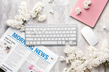 Composition with beautiful lilac flowers, PC keyboard and newspaper on light backgroundの写真素材