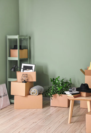 Cardboard boxes with accessories in new flat on moving dayの写真素材