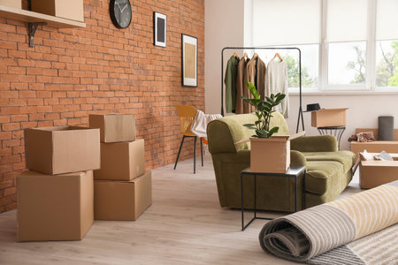 Cardboard boxes with accessories in new flat on moving dayの写真素材