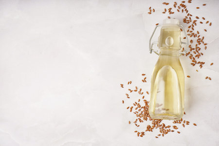 Bottle with flax oil and seeds on light backgroundの写真素材