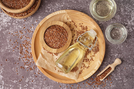 Bottle with flax oil and seeds on gray grunge backgroundの写真素材