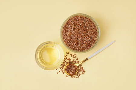 Glass with flax oil and seeds on yellow backgroundの写真素材