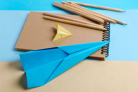 Composition with stationery supplies and paper planes on color background