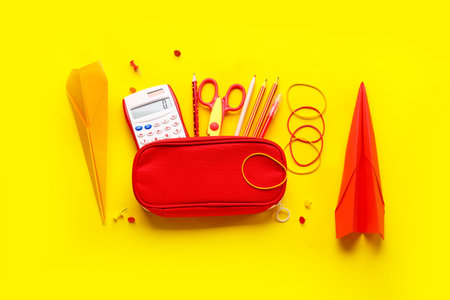 Composition with stationery supplies and paper planes on yellow background