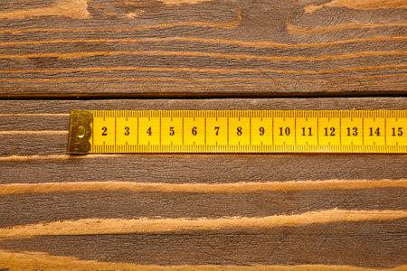 Yellow measuring tape on wooden backgroundの写真素材