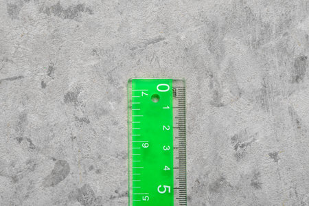 Green plastic ruler on gray grunge backgroundの写真素材