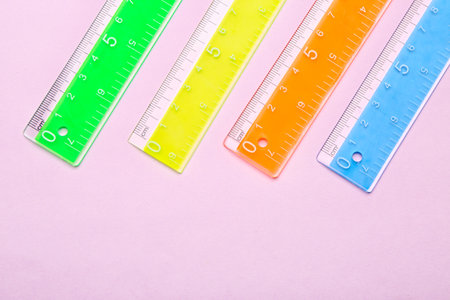 Colorful plastic rulers on pink backgroundの写真素材
