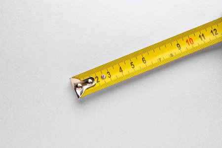 Measuring tape on gray background
