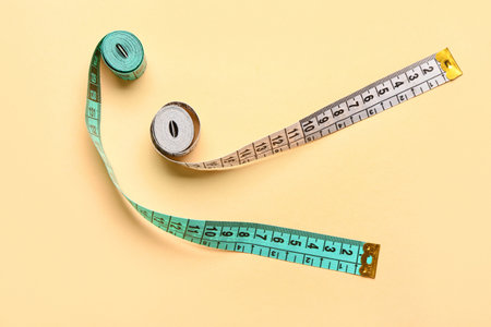 White and blue measuring tapes on beige backgroundの写真素材