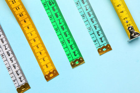 Colorful measuring tapes on blue backgroundの写真素材