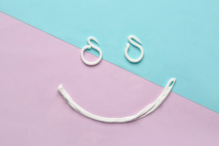 Smile made of sunscreen cream on color background