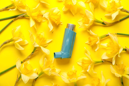 Inhaler with flowers on yellow background