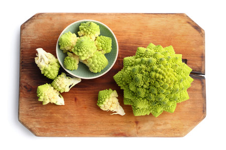 Wooden board and bowl with romanesco cabbage on white backgroundの写真素材