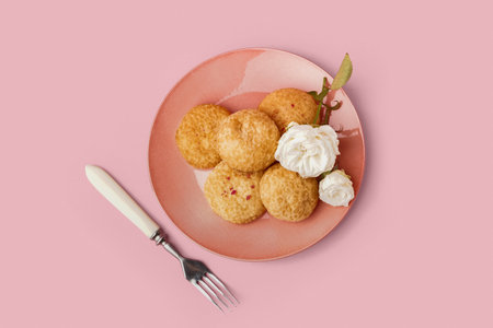 Plate with tasty choux dessert on pink backgroundの写真素材
