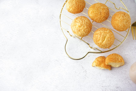 Grid with tasty choux dessert on light background, closeup