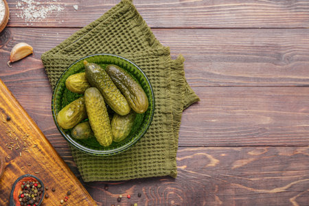 Bowl with tasty fermented cucumbers on wooden backgroundの写真素材