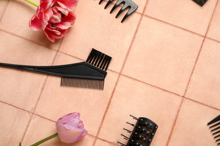 Composition with hairdresser tools and tulip flowers on tiled table