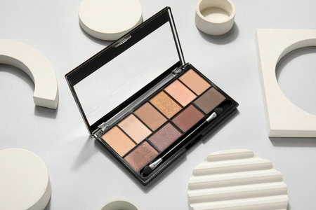 Palette of eyeshadows with brush and podiums on light backgroundの写真素材