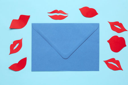 Envelope with red paper lips on blue backgroundの写真素材