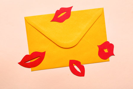 Envelope with red paper lips on beige backgroundの写真素材