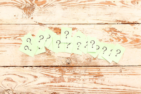 Sticky notes with question marks on white wooden backgroundの写真素材