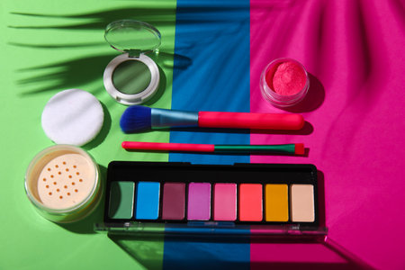 Decorative cosmetics with brushes on color backgroundの写真素材