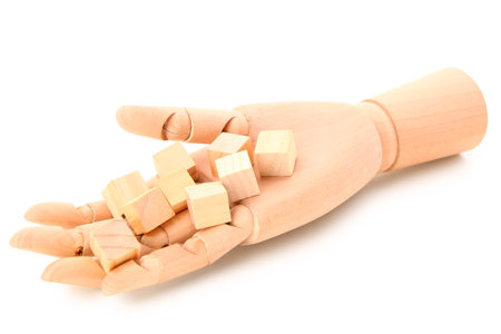 Wooden hand with cubes isolated on white backgroundの写真素材