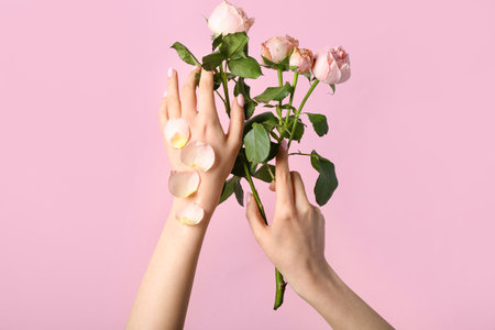 Woman with roses on pink background. hand care conceptの写真素材