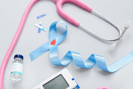 Awareness ribbon with glucometer, insulin and stethoscope on light background. Diabetes concept