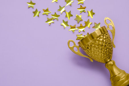 Gold cup with stars on lilac background, closeupの写真素材