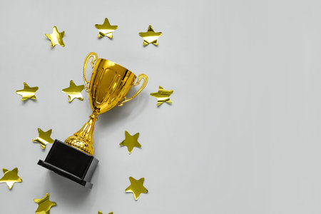 Gold cup with stars on gray background