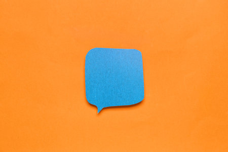 Blank paper speech bubble on orange background