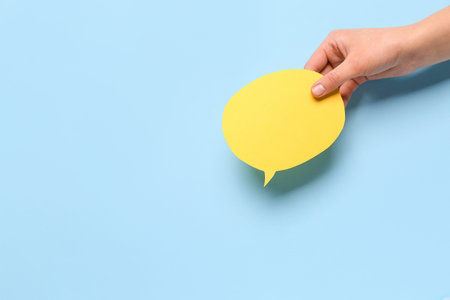 Woman holding blank speech bubble on blue background