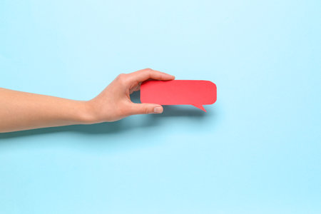 Woman holding blank speech bubble on blue backgroundの写真素材