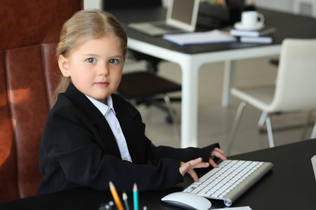 Funny little businesswoman working with computer at table in officeの写真素材
