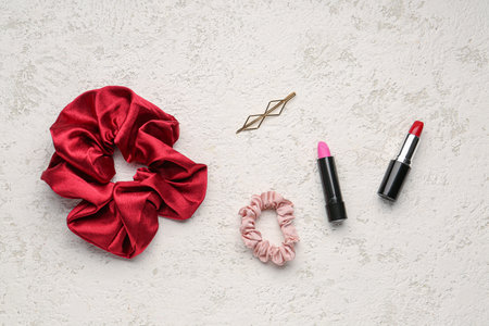 Silk scrunchies, hairpin and lipsticks on light backgroundの写真素材