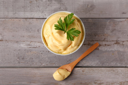 Bowl with tasty mayonnaise sauce on gray wooden backgroundの写真素材