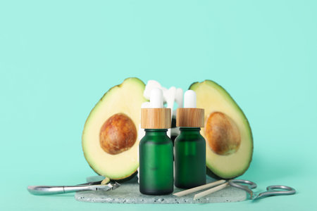 Composition with bottles of cuticle oil, manicure instruments and avocado on color backgroundの写真素材