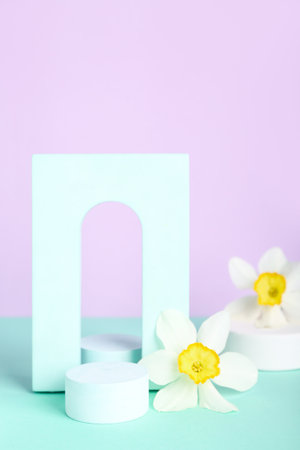 Decorative plaster podiums with flowers on turquoise table against violet backgroundの写真素材