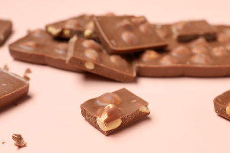 Sweet tasty chocolate with nuts on light pink background, closeupの写真素材