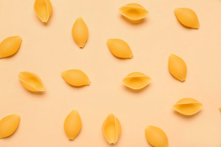 Raw conchiglie pasta on yellow backgroundの写真素材
