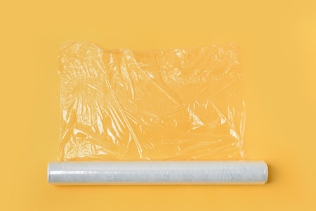 Roll of stretch wrap on yellow backgroundの写真素材