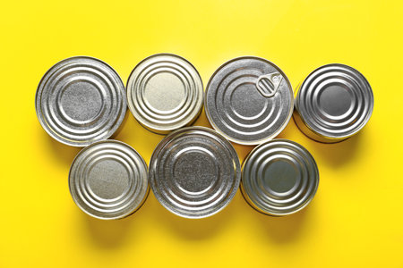Assortment of tin cans with fish on yellow backgroundの写真素材