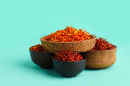 Bowls with pile of saffron on blue backgroundの写真素材