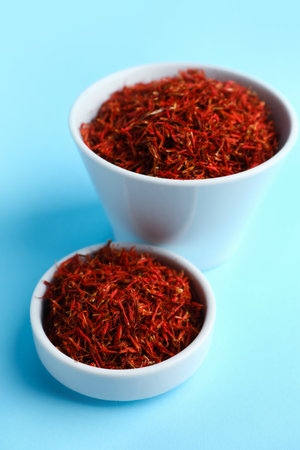Bowls with pile of saffron on blue backgroundの写真素材