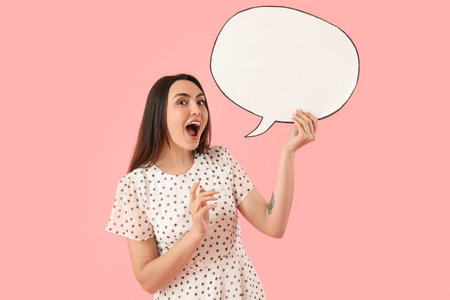 Young woman with blank speech bubble on pink background
