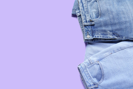 Stylish jeans on lilac background, closeupの写真素材
