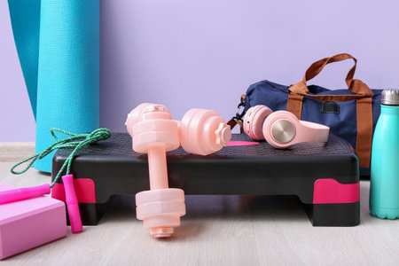 Sports equipment with headphones near lilac wall in gym, closeupの写真素材