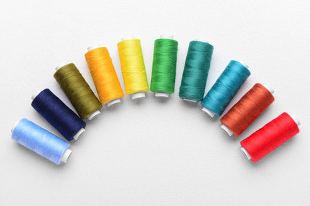 Set of colorful sewing threads on light background