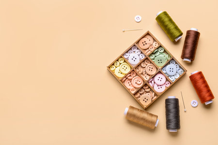 Composition with different buttons, thread spools and ball pins on color background
